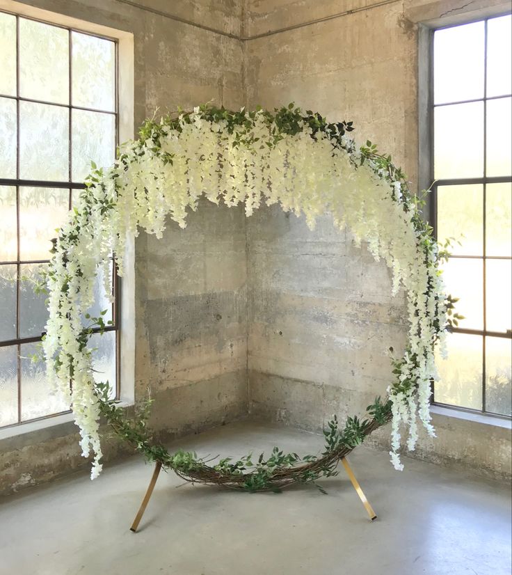 an arrangement of white flowers and greenery in a room