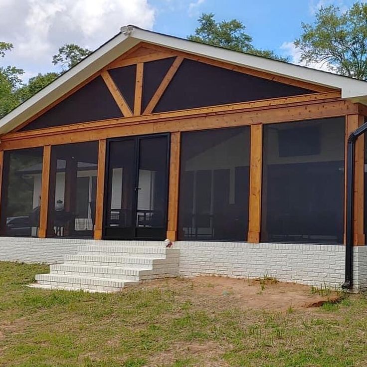 a house that is sitting in the grass with some windows on it's side