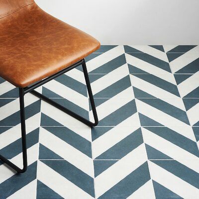 a brown leather chair sitting on top of a white and blue floor next to a wall