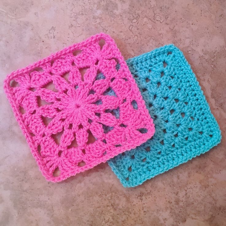 two crocheted squares sitting on top of a floor next to each other in different colors