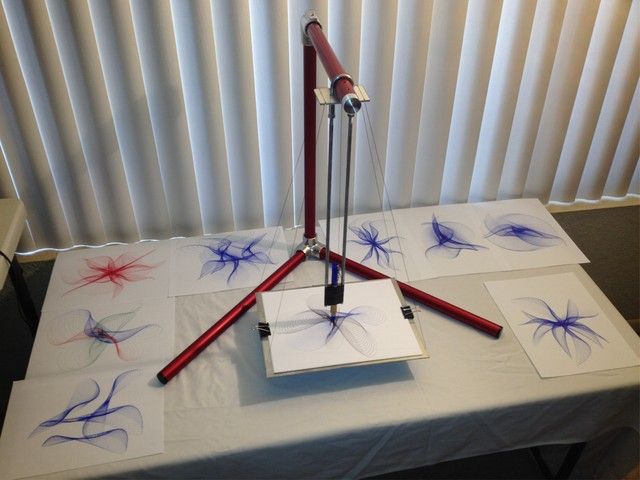 a table topped with three different types of art work on top of white cloth covered tables