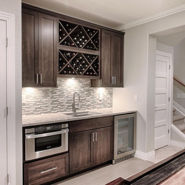 a wine rack in the middle of a kitchen with wooden cabinets and stainless steel appliances