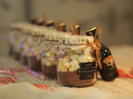 jars filled with hot chocolate and marshmallows are lined up on a table