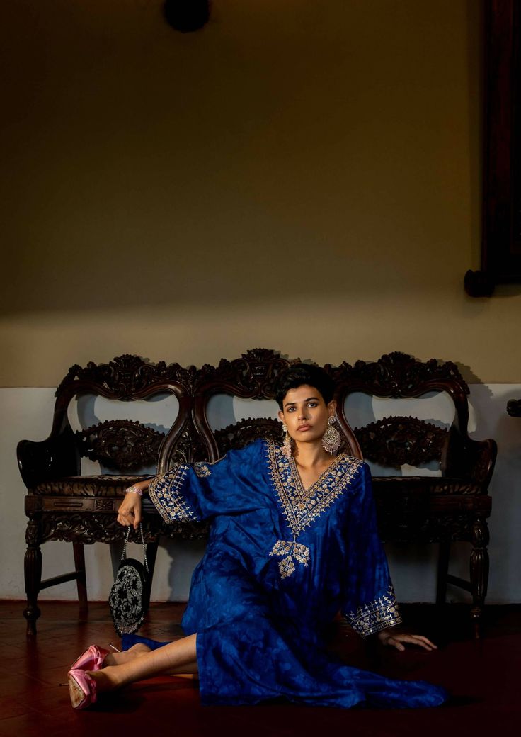 Our deep blue self-woven kaftan set showcase beautiful hand embroidery on yoke and cuffs. This elegant piece comes embellished with careful antique embroidery detailing. The soothing nature inspired woven technique details all over adds charm to this timeless outfit. Blue Traditional Ceremonial Kaftan, Silk Blue Kurta With Intricate Embroidery, Festive Blue Dress With Embroidered Border, Bohemian Ceremonial Kaftan With Zari Work, Blue Traditional Drape Dress With Embroidered Border, Blue Tunic Kurta For Festivals, Designer Blue Dresses With Embroidered Border, Blue Dresses With Embroidered Border For Festive Occasions, Blue Dress With Embroidered Border For Festive Occasions