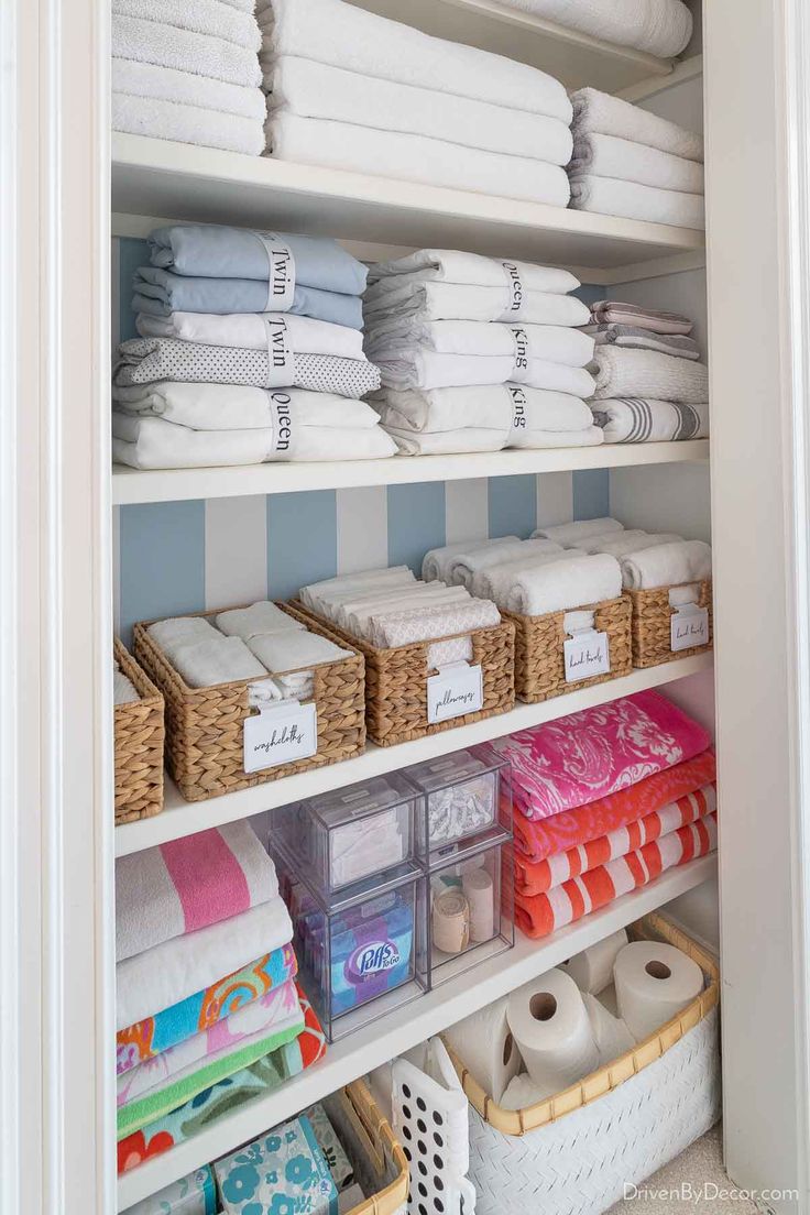 organized linen closet with folded towels and baskets