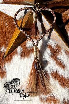 a brown and white cow print with a star on it's side, hanging from a metal hook