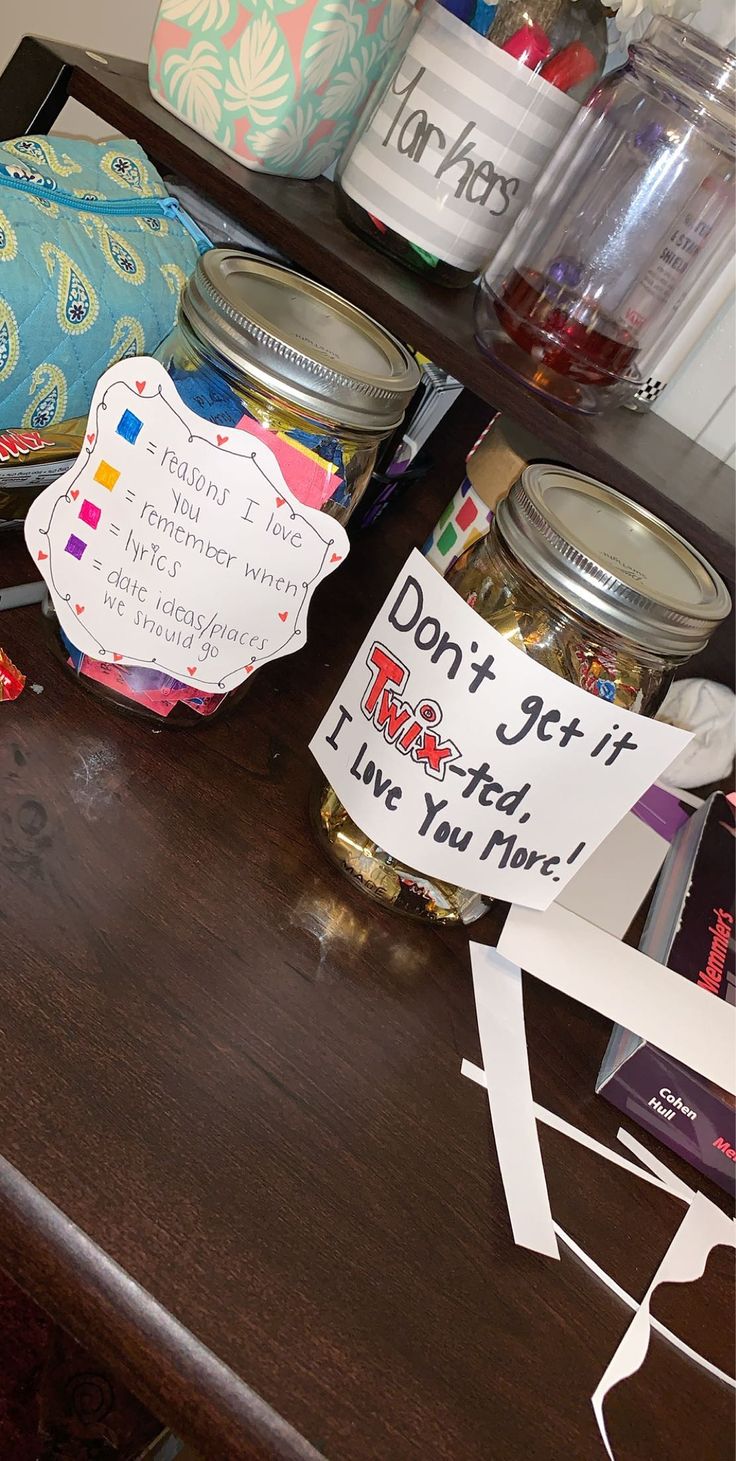 a wooden table topped with lots of jars filled with food next to a sign that says don't get it