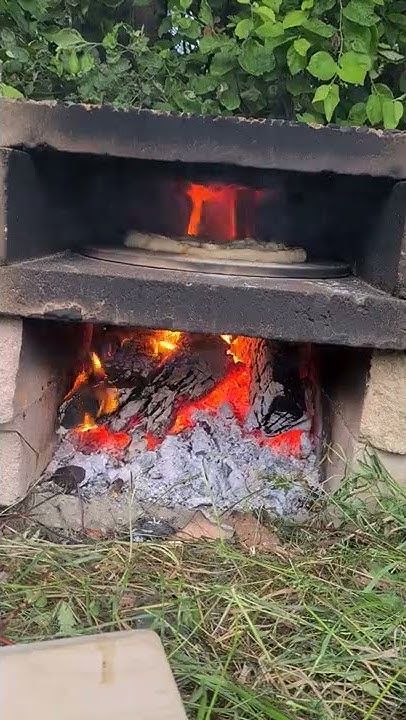 an open fire pit sitting in the grass