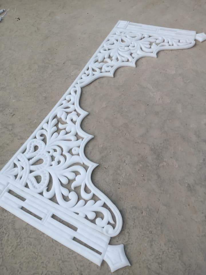 an ornate white iron design on the ground