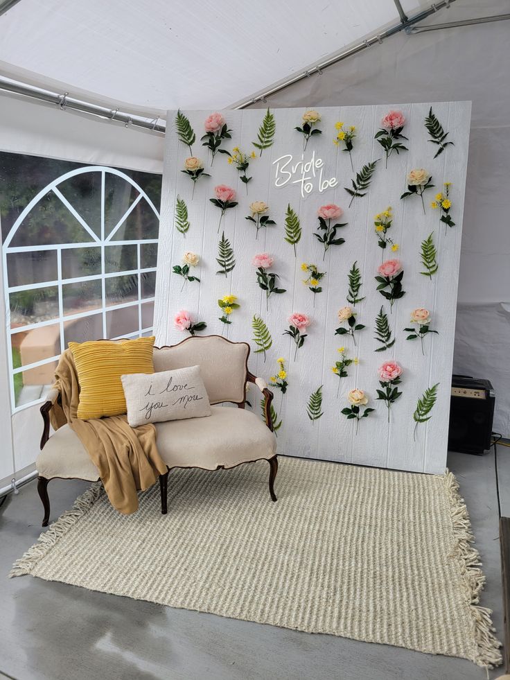 a chair sitting on top of a rug next to a wall with flowers and leaves