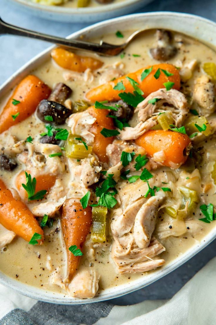 two bowls of soup with carrots, celery and meat