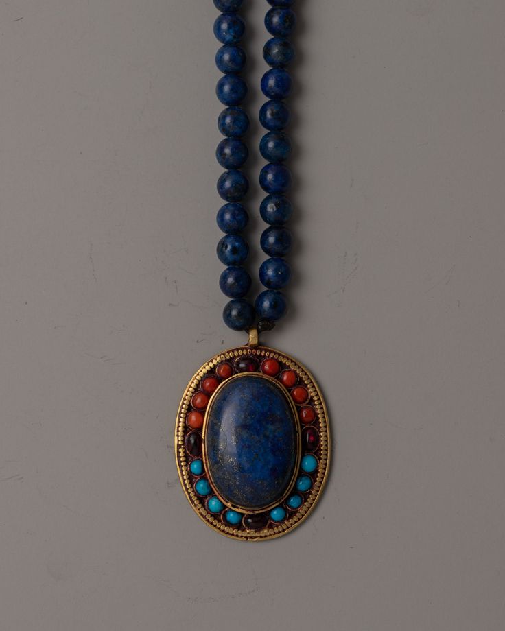 Lapis Lazuli Bead Necklace About Our Locket The Lapis Lazuli Bead Necklace, carefully made by hand with precise attention to detail, is a beautiful expression of elegance and spirituality. The copper locket, which has electrogold plating on it, is a dramatic focal point. Coral, turquoise, and garnet are among the priceless jewels that are meticulously inlaid into each facet of the locket to further enhance its beauty and symbolic meaning. This necklace is much more than just jewelry; it has deep Traditional Jewelry With Round Lapis Lazuli Beads, Traditional Lapis Lazuli Round Bead Necklace, Traditional Lapis Lazuli Bead Necklace, Traditional Lapis Lazuli Gemstone Beads Necklace, Traditional Lapis Lazuli Necklace With Gemstone Beads, Blue Amulet Necklace, Hand-strung, Traditional Lapis Lazuli Beaded Necklace, Blue Amulet Style Hand-strung Necklace, Blue Handmade Amulet Necklace