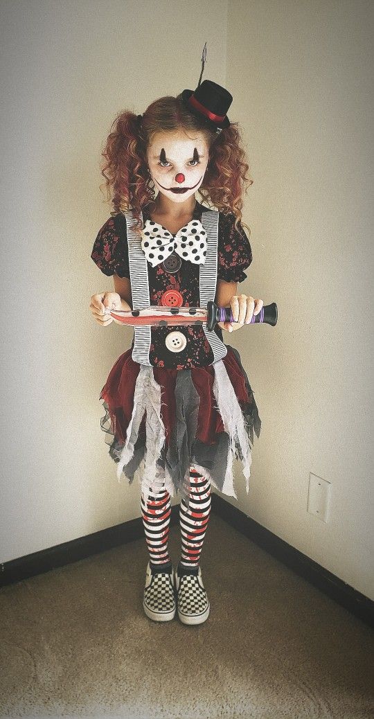 a doll dressed as a clown holding a skateboard