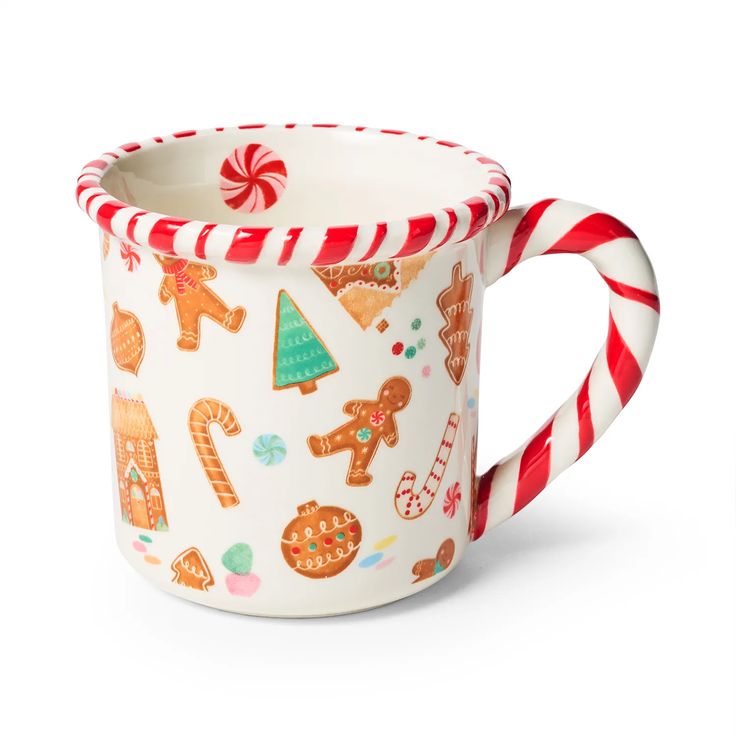 a white mug with candy canes and gingerbread cookies on the inside is sitting in front of a white background