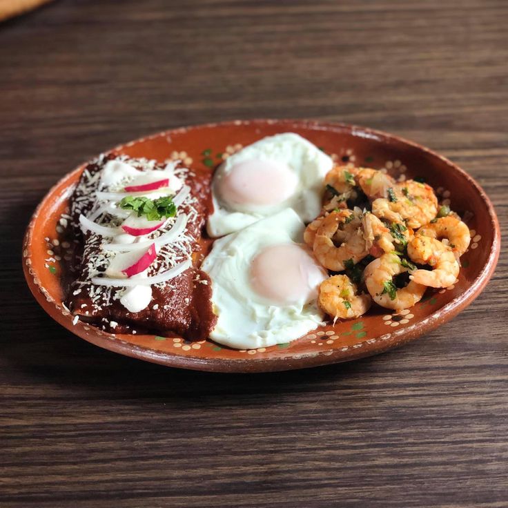 a brown plate topped with food on top of a wooden table