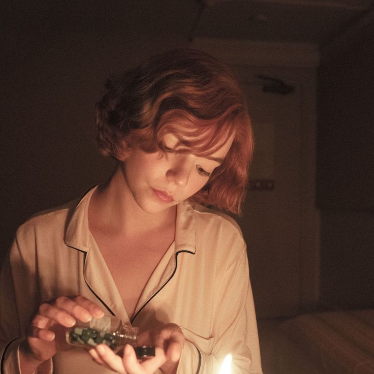 a woman holding a piece of food in her hands while looking down at the cake