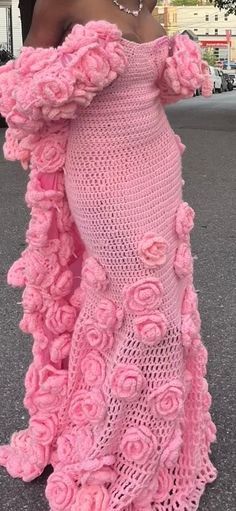 a woman wearing a pink dress with roses on it