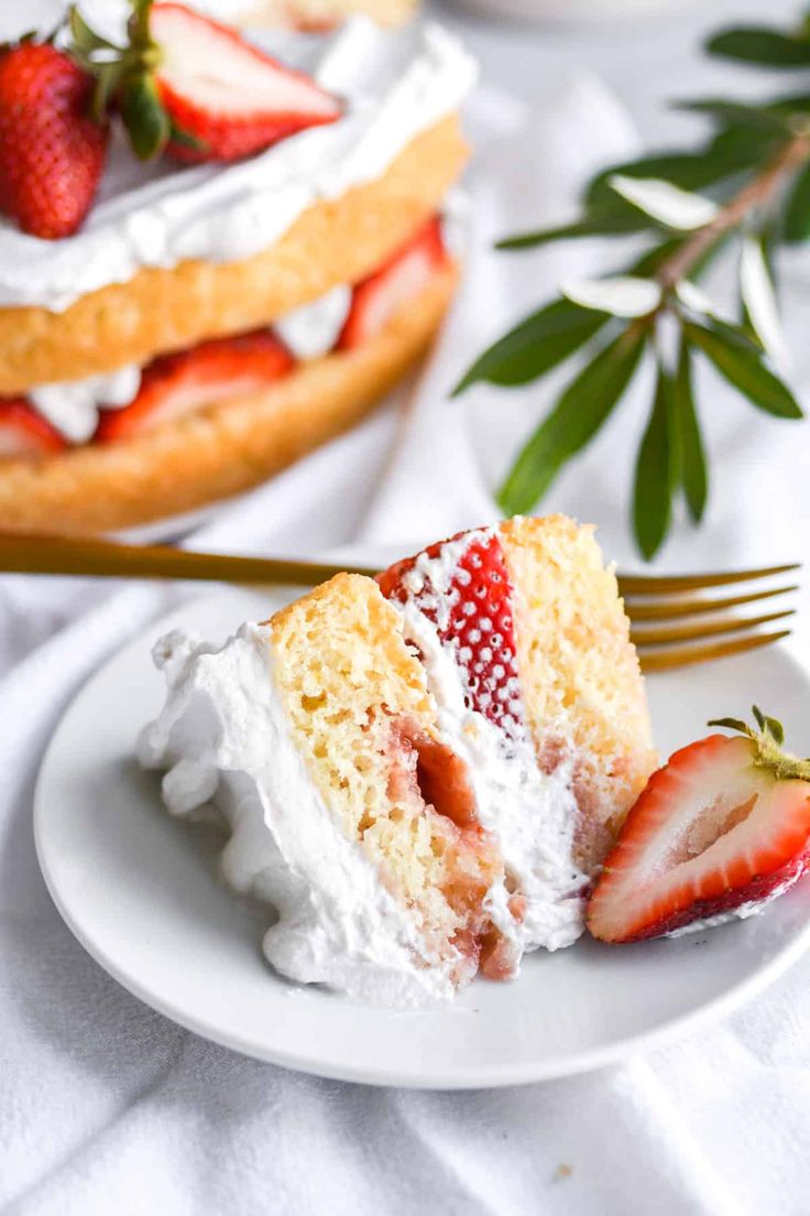 a piece of cake with whipped cream and strawberries on top