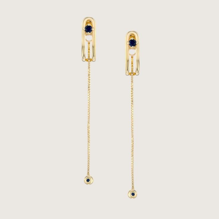 An impressive and special earring with a design element in the form of a vertical clasp inspired by the world of tailoring that characterizes the TAILORED collection. The top of the element is studded with a 3 mm Sapphire that gives the earring a powerful look without detracting from its delicacy. A delicate chain with a Sapphire studded gold ball at the end, threaded from the bottom of the earring, adds an elegant sway to this special piece. The earring is inspired by the buttons and cuffs that make up the female suit and is part of the TAILORED collection The earrings are sold as singles All features can be customized! Please contact us if you wish to make changes, we love making custom designs. All of our jewelry is carefully handmade in our atelier. *HC diamond are all conflict-free di Luxury Drop Earrings With 17 Jewels, Luxury Yellow Gold Linear Earrings, Luxury Yellow Gold Dangle Clip-on Earrings, Luxury Dangle Hoop Earrings For Formal Occasions, Timeless Evening Earrings With 17 Jewels, Fine Jewelry Linear Pierced Earrings For Evening, Fine Jewelry Linear Earrings For Evening, Clip-on Dangle Earrings In Yellow Gold, Yellow Gold Clip-on Dangle Jewelry