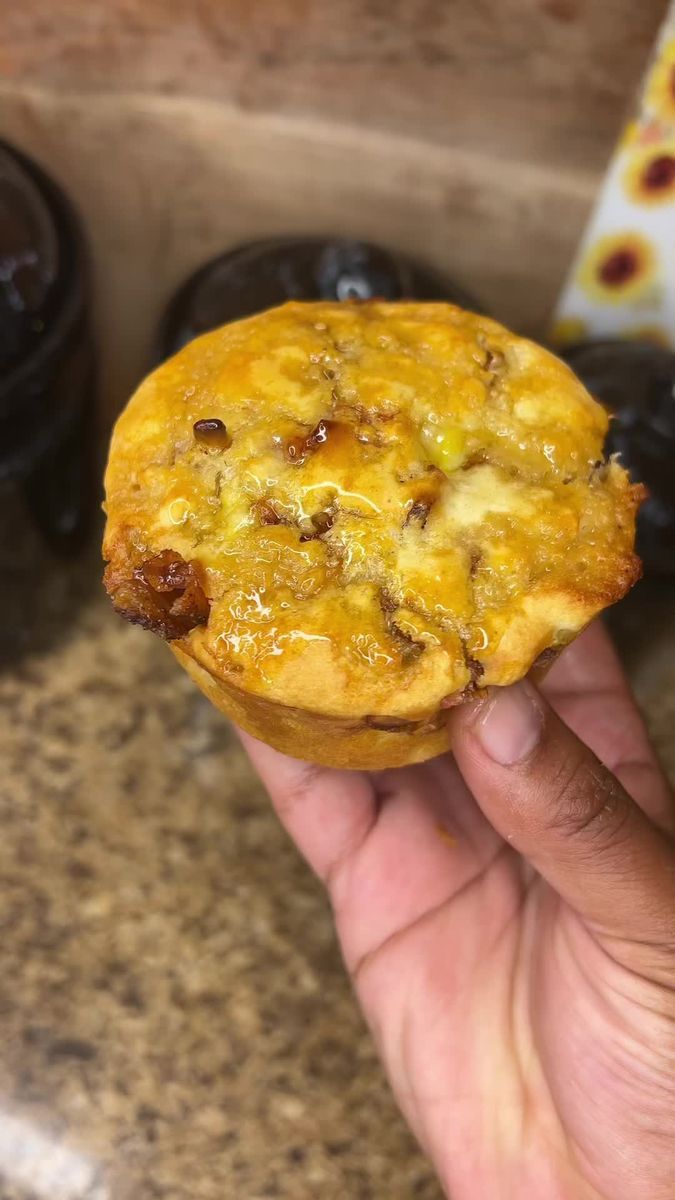 a hand holding a muffin in front of some blueberries and other food items