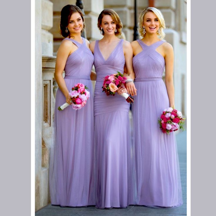 three bridesmaids in lavender colored dresses posing for the camera