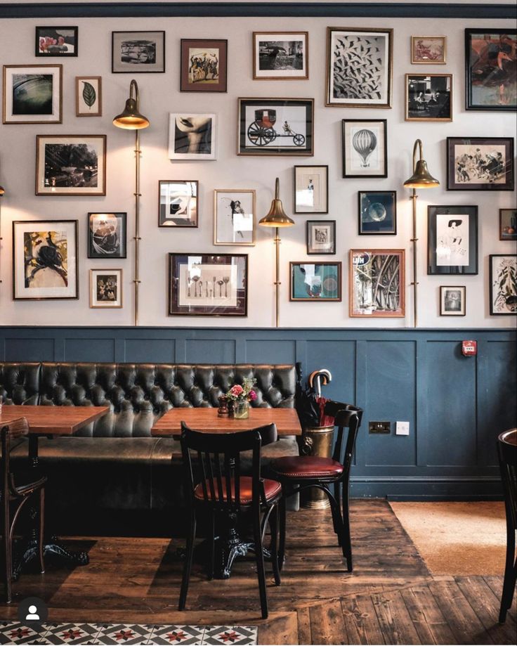 a restaurant with tables, chairs and pictures on the wall above it's booth