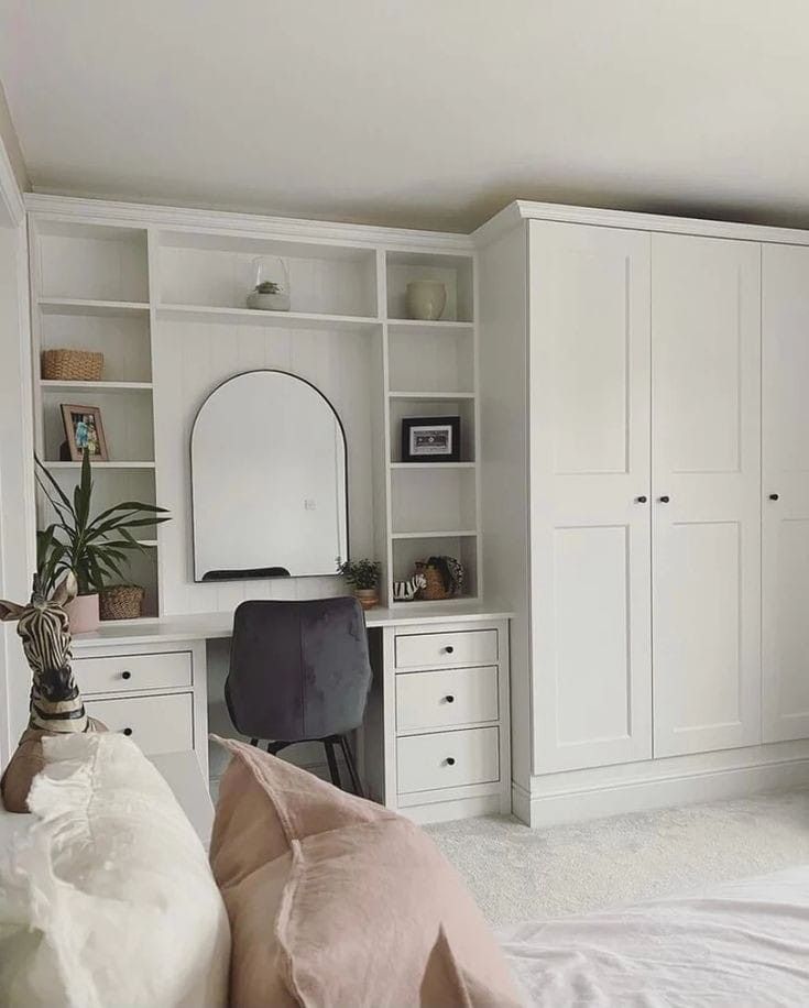 a bedroom with white furniture and shelves filled with bookshelves, desks, and a mirror