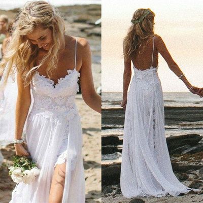 two women in white dresses walking on the beach