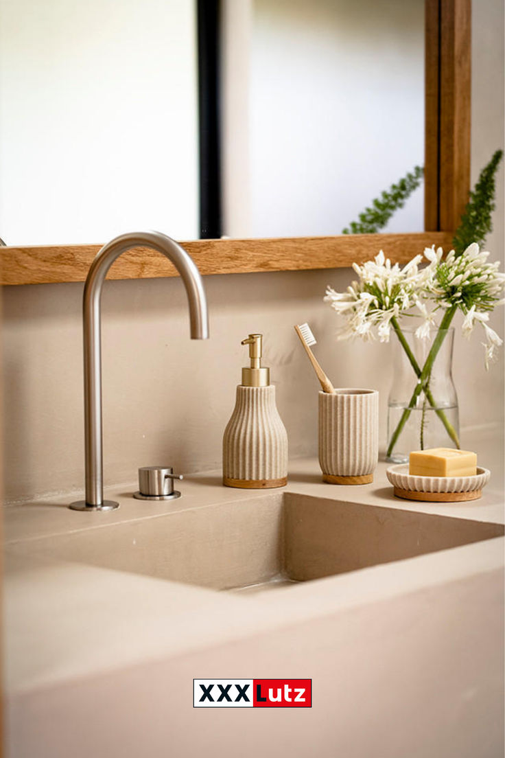 a bathroom sink with soap dispenser, toothbrush holder and flower vase