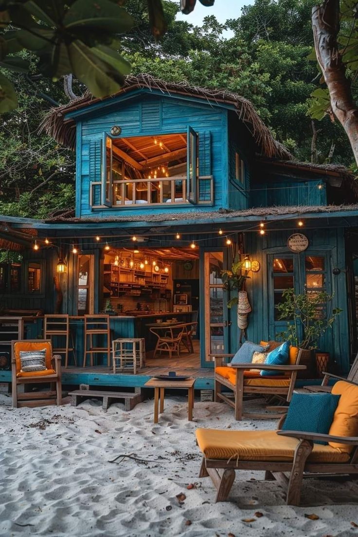 a blue building with lots of windows on the beach