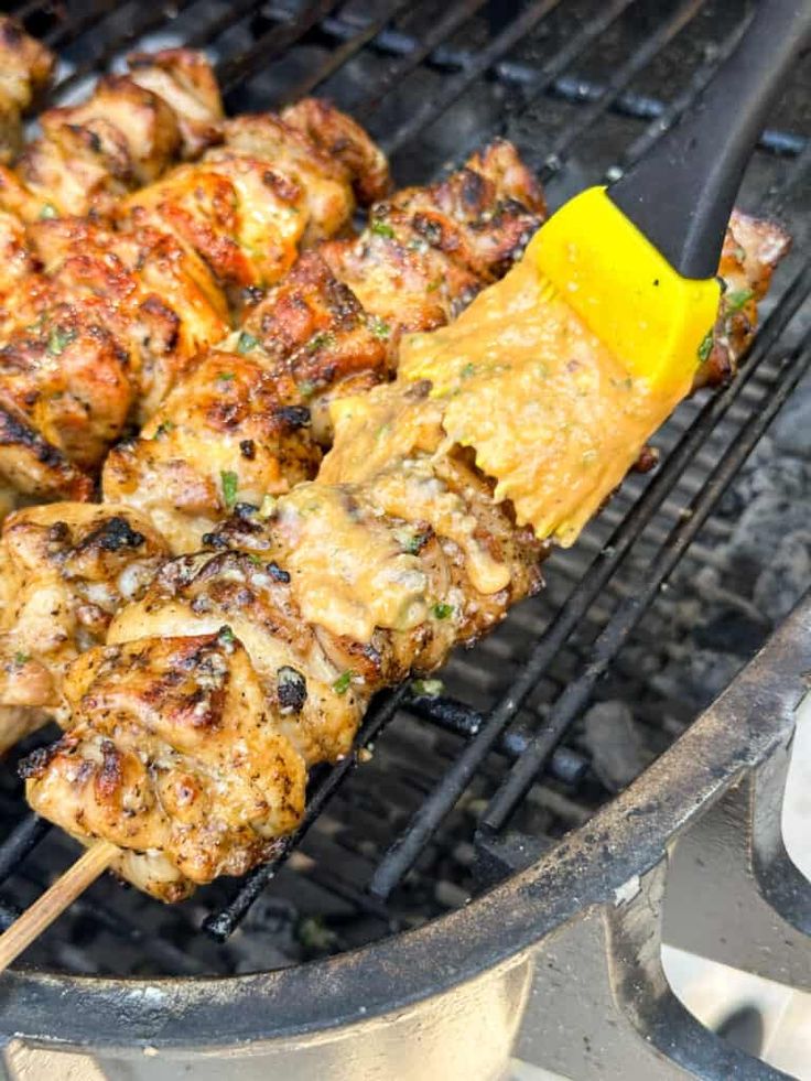 chicken skewers are being cooked on the grill