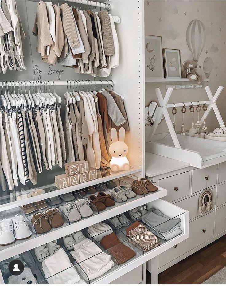 a white closet filled with lots of baby clothes