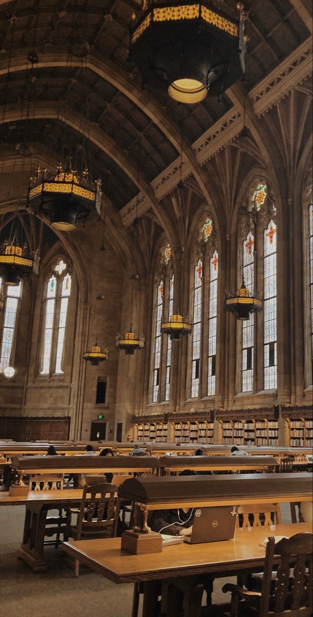 the interior of a library with tables and chairs in front of large windows that look like they are made out of wood