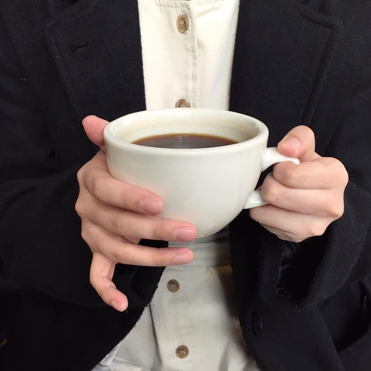 a person holding a cup of coffee in their hands