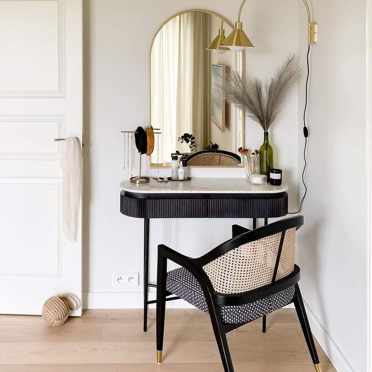 a table with a mirror, chair and vase on it