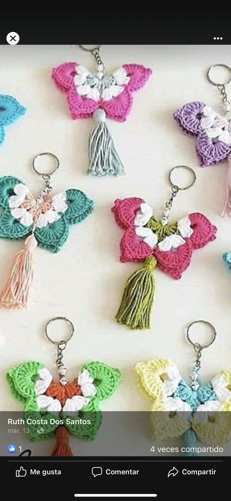 crocheted keychains with tassels are arranged on a white surface