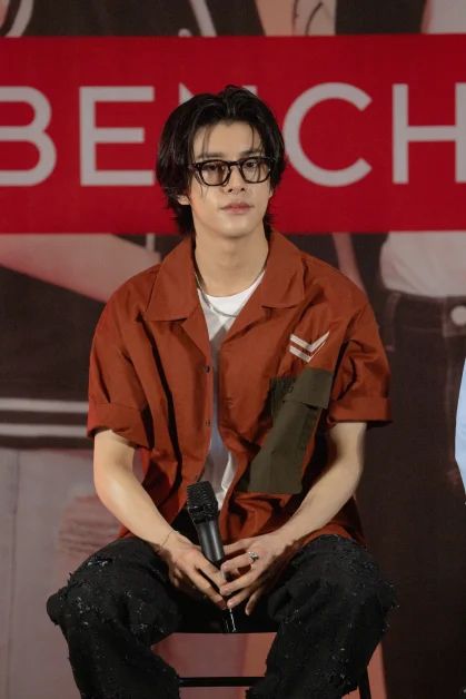 a man sitting on top of a chair in front of a sign