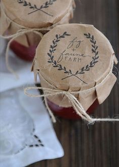 two small jars with labels on them are sitting on a table next to some napkins