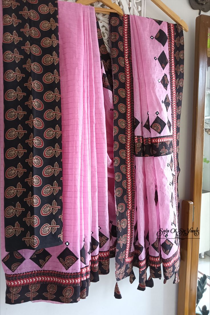 This enchanting baby pink color #handloomcottonsaree is a vision of grace and #elegance, blending #tradition with contemporary charm. Crafted from cotton, it presents a delightful fusion of #colors and intricate detailing, making it a versatile choice for various occasions, especially for the upcoming #festive season. Its #patchwork design, featuring two distinct #handblock #ajrakh printed #purecotton fabrics in black and maroon. #sareeusa #style #fashion #indianoutfit #pinksaree #shoponline Festive Cotton Pre-draped Saree With Printed Border, Festive Cotton Pre-draped Saree With Block Print, Traditional Pink Saree With Block Print, Bohemian Cotton Saree With Cutdana, Pink Cotton Handloom Saree, Cotton Traditional Wear With Printed Border, Pink Chanderi Saree With Block Print, Pink Block Print Saree For Festivals, Cotton Saree With Block Print