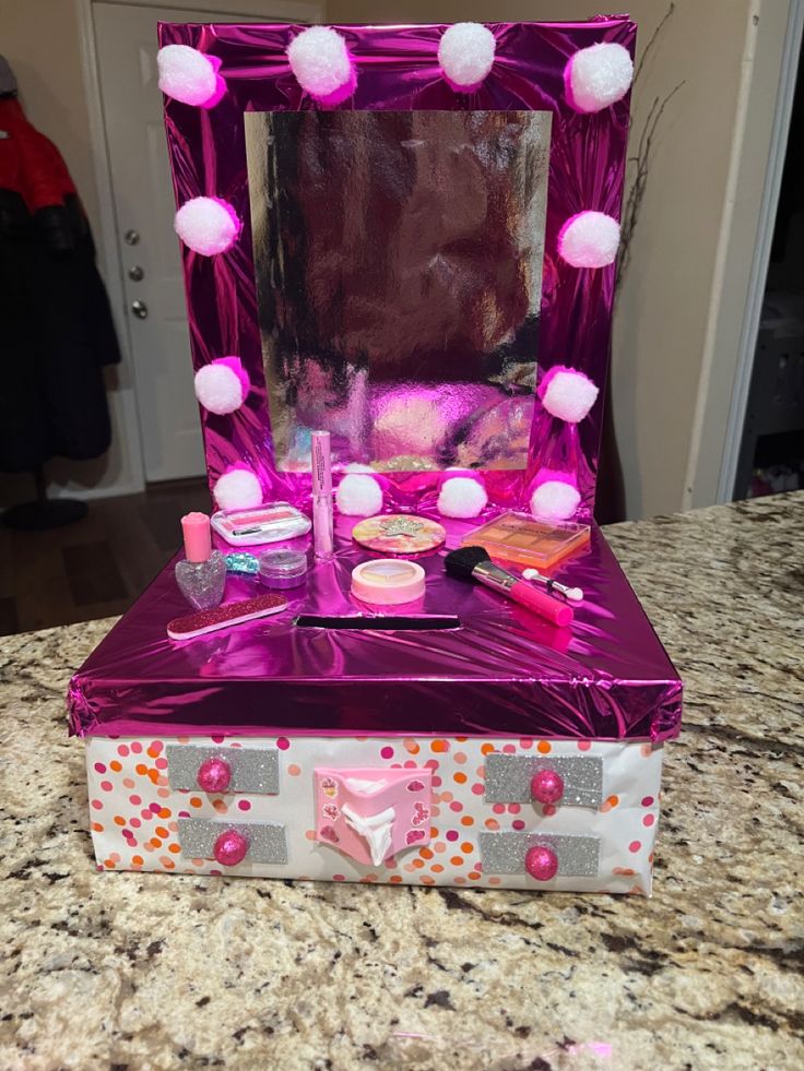 a pink vanity with pom - poms on it sitting on top of a counter