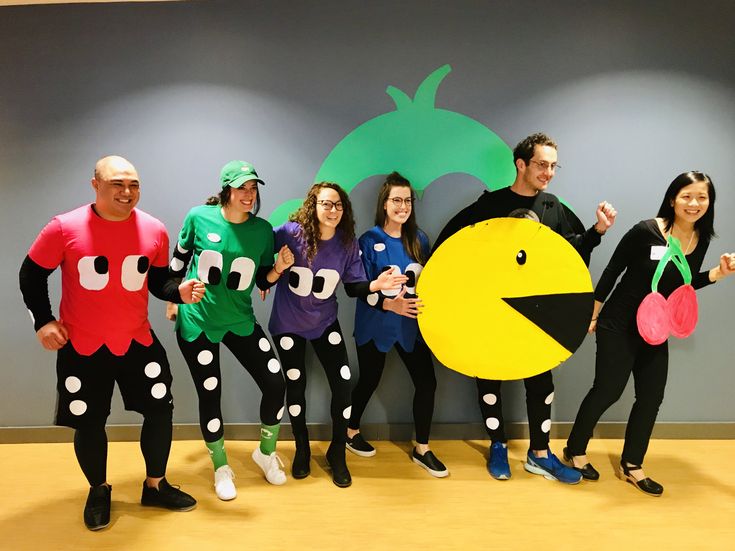 a group of people dressed in costumes posing for a photo with one person holding an object