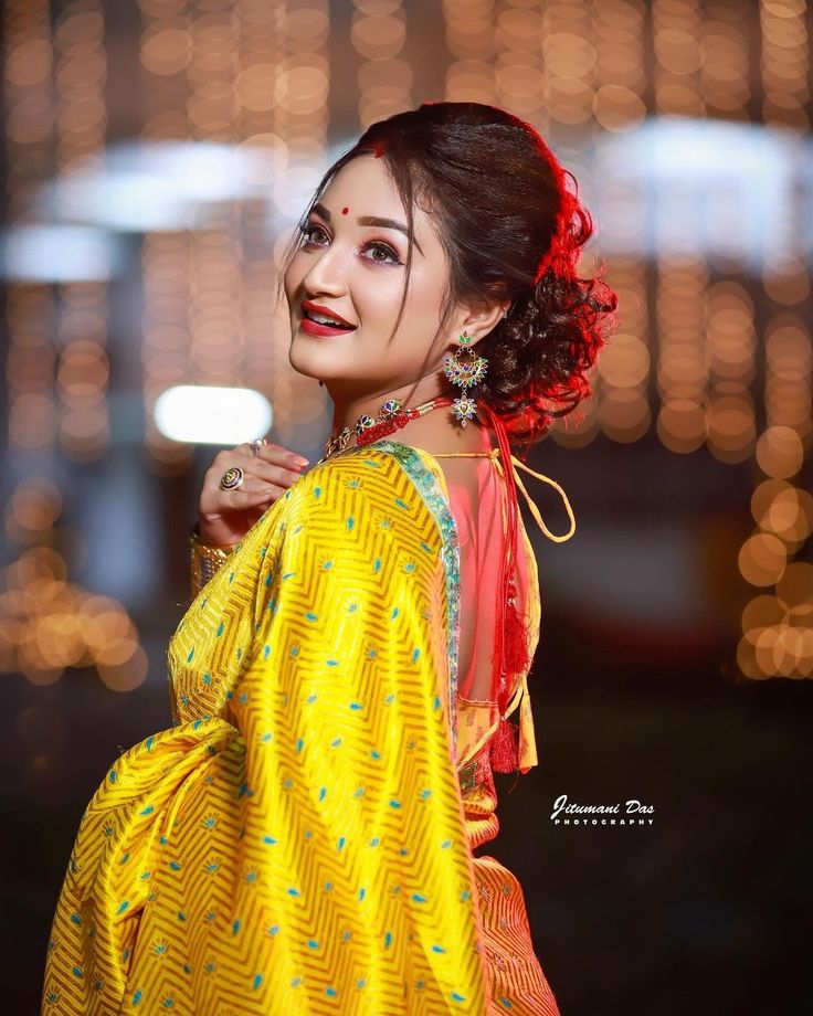 a woman in yellow and red is posing for the camera