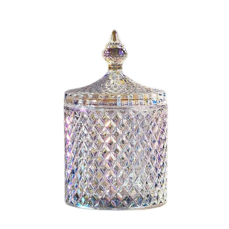 a clear glass jar with a diamond design on the top and bottom, is shown in front of a white background