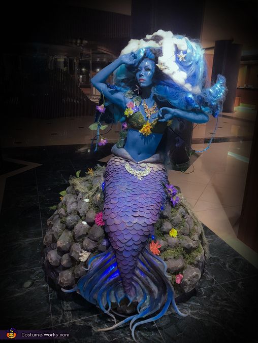 there is a statue of a mermaid with blue hair and makeup on it's head