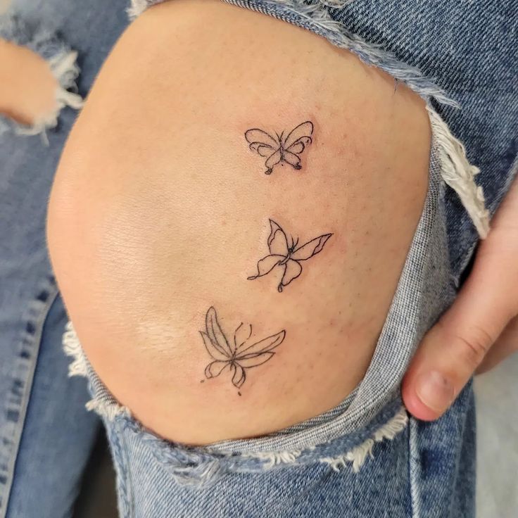 a woman's stomach with three butterflies on it