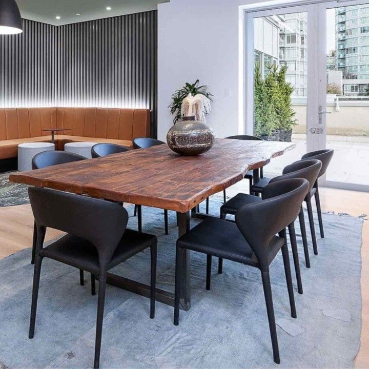 a large wooden table surrounded by black chairs