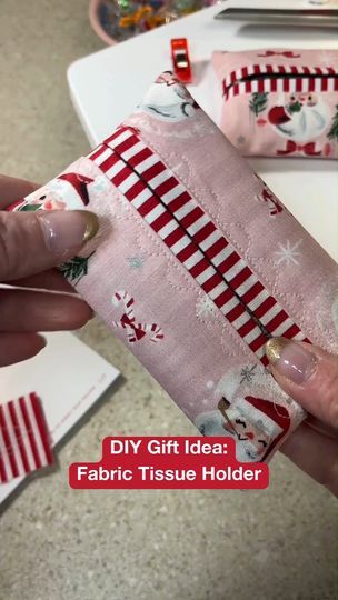 a person is holding a piece of fabric with christmas decorations on it and the words diy gift idea fabric tissue holder