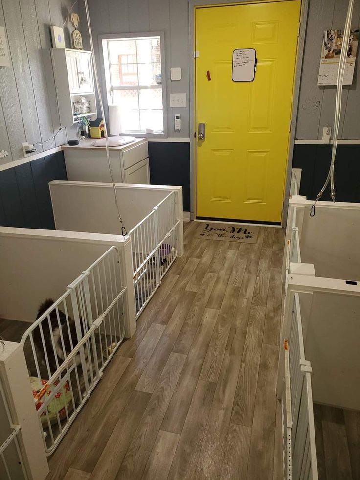 a yellow door sits in the middle of a room with white cribs and wooden floors