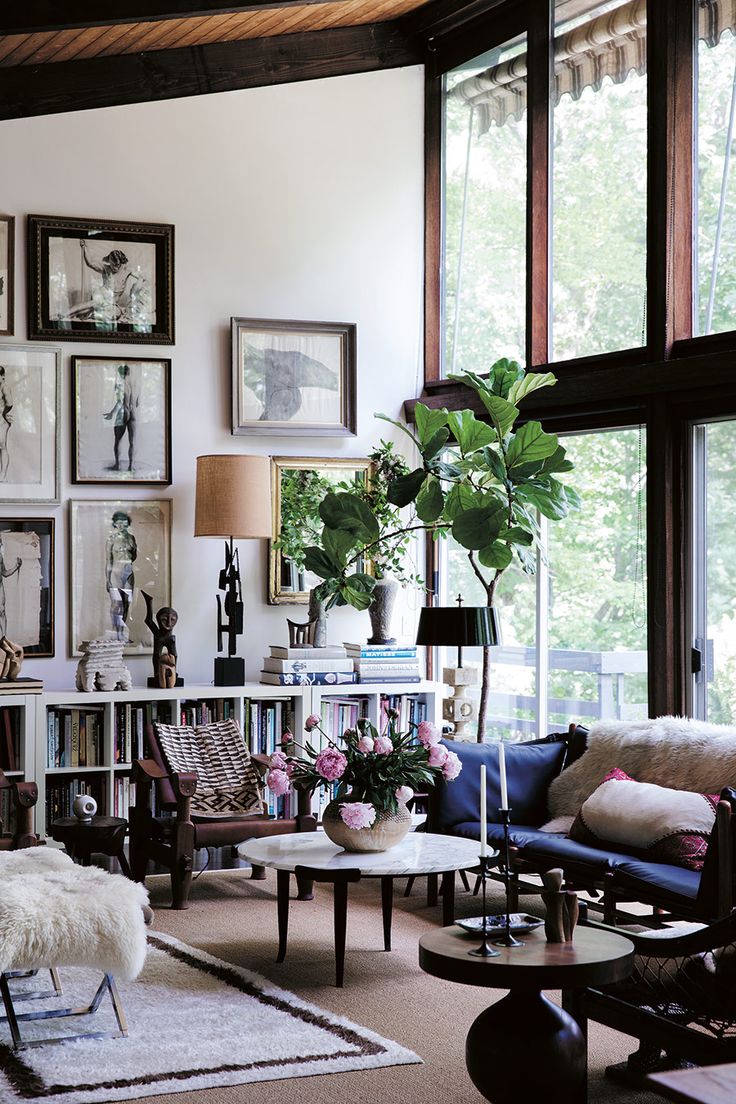 a living room filled with furniture and lots of pictures on the wall above it's bookshelf