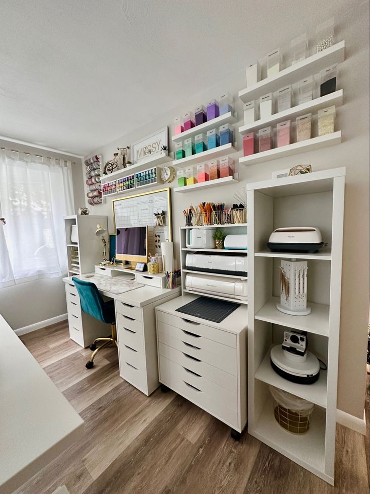 a white desk with lots of craft supplies on top of it in a home office